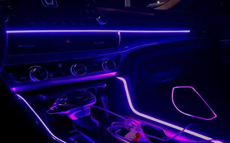 Tiras LED de colores para automóviles instaladas bajo el salpicadero del coche que crean una iluminación interior ambiental